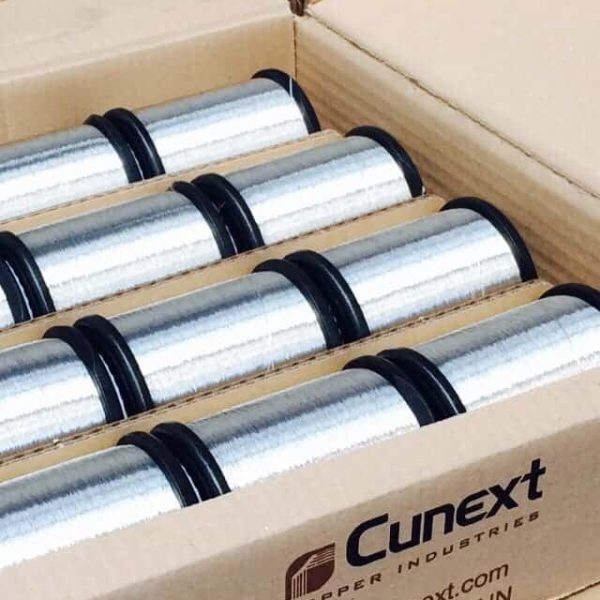 Bobinas de hilo de cobre estañado de alta precisión en caja de transporte industrial de Cunext Copper Industries.